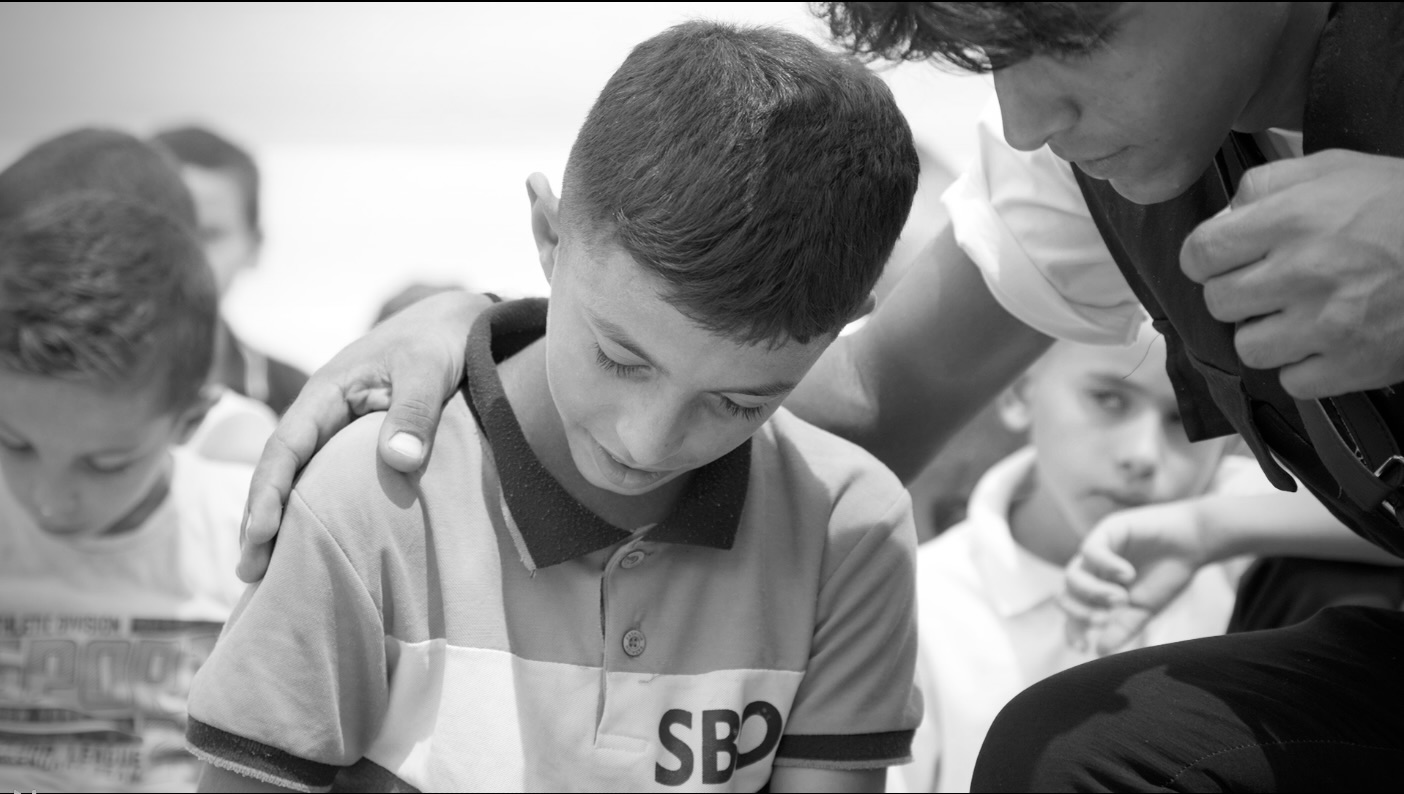 A hand on a boy's shoulder
